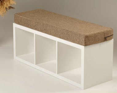 Kahverengi yastıklı koltuklu modern beyaz depolama tezgahı rahat oturma ve depolama alanı sağlıyor