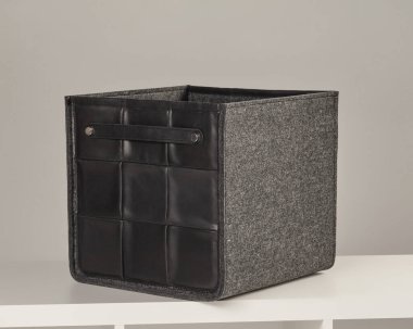 Modern gri keçeli kutu siyah deri detaylarla dolu, şık bir organizasyon sunuyor.