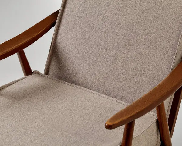 Ahşap çerçeveli ve bej döşemeli rahat modern koltuk şık bir oturma çözümü sunuyor.