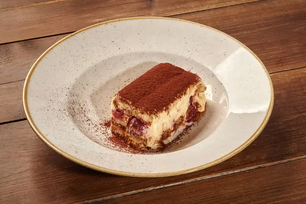 Bir dilim tiramisu, kahve katmanları, mascarpone kreması ve kakao tozu içeren klasik bir İtalyan tatlısı.