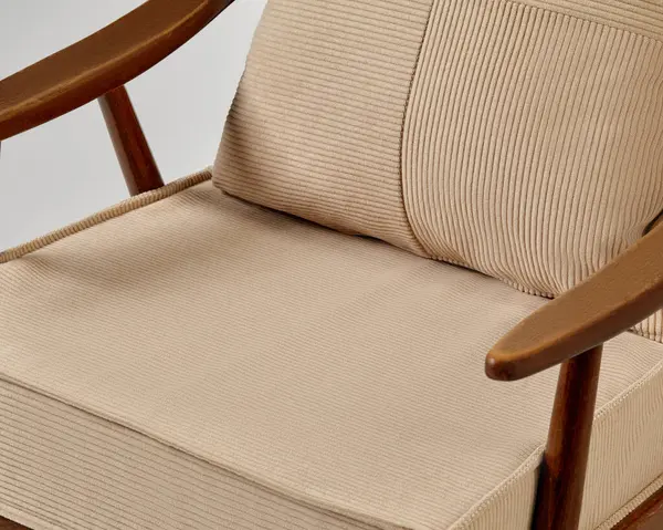 Ahşap çerçeveli modern koltuk ve bej kadife döşeme şık ve rahat bir oturma çözümü sunar.