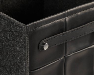 Zarif siyah deri bir depolama kutusu yumuşak keçeli astarı, ince işçiliği ve minimalist bir tasarımı var.