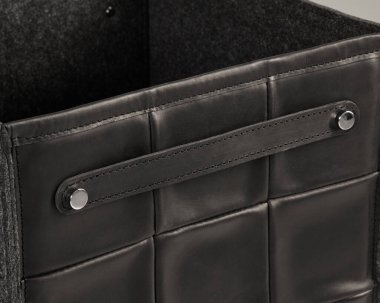 İçinde keçeli astar ve sağlam bir metal sapı olan şık siyah deri bir kutunun yakın çekimi.