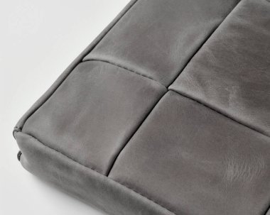 Görünür dikiş ve doku ile gri deri yüzey, yüksek kalitede işçiliği işaret ediyor.