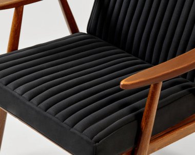 Rahat bir şezlong, siyah kurdeleli döşeme ve ahşap çerçeve, rahatlama ve stil arayan modern iç mekanlar için idealdir.
