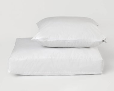 Beyaz arka planda temiz su geçirmez yastık ve yatak koruyucusu, hijyen ve konforu destekliyor.