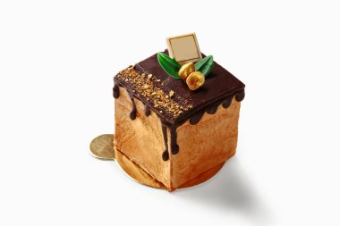 Damlayan çikolatalı ganache, altın taneli küçük kare tatlı ve lüks bir ziyafet yaratan Braun aile logosu.