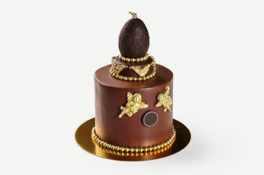 Altın çikolata melekleriyle süslenmiş çikolatalı pasta lüks ve şenlikli bir tatlı yaratıyor.