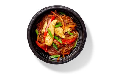 Siyah kasede servis edilen tavuk ve sebzeli leziz selofan şehriye sağlıklı Asya mutfağını temsil ediyor.