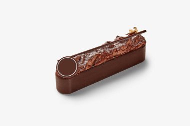 Üstü desenli çikolatalı tatlı barı, altın yapraklı aksanı ve dairesel çikolata süslemesi var.