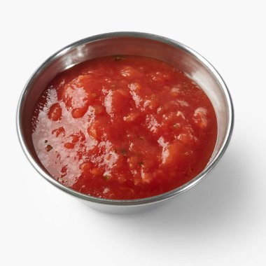 Küçük paslanmaz çelik kâse taze domates sosunu otlarla sunuyor, canlı ve lezzetli bir görüntü yaratıyor.