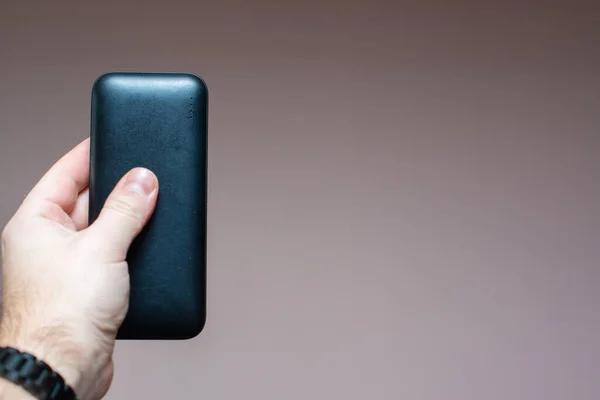 a portable battery for gadgets in a man\'s hand