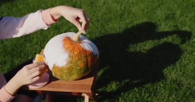 10 yaşında bir kız balkabağı boyar, Cadılar Bayramı için mücevher hazırlar..