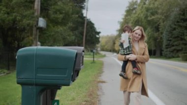 Çocuklu bir kadın mektup göndermek için posta kutusuna gider. 4k video