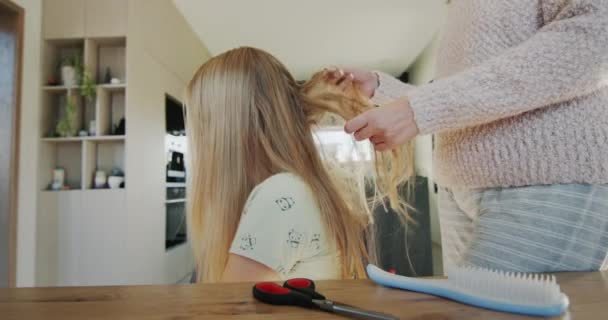 母は娘の髪を長い髪に絡ませる 髪は非常に絡み合っていて櫛が難しいです — ストック動画