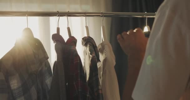 Homme Choisit Ses Vêtements Près Étagère Avec Cintre Derrière Est — Video