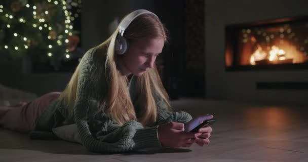 Una Chica Con Auriculares Usa Teléfono Inteligente Encuentra Suelo Una — Vídeos de Stock