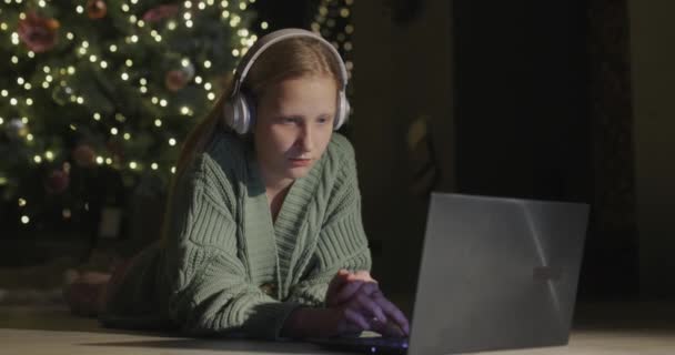 Puberťačka Používá Notebook Ležel Podlaze Pozadí Velkého Krásného Vánočního Stromku — Stock video