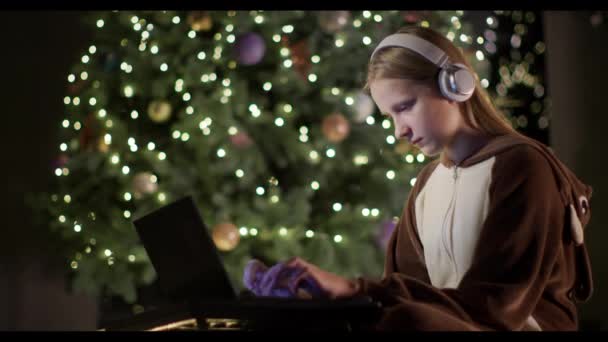 Egy Szarvas Jelmezes Tinédzser Laptopot Használ Egy Nagy Karácsonyfa Hátterében — Stock videók