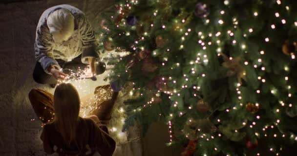 Dziecko Babcia Przygotowują Się Świąt Rozplątują Girlandy Pod Wielką Choinką — Wideo stockowe