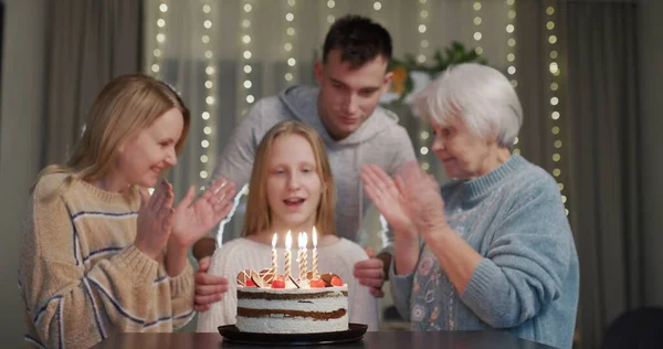 Uma Adolescente Apaga Velas Bolo Aniversário Perto Seus Parentes Batendo — Fotografia de Stock