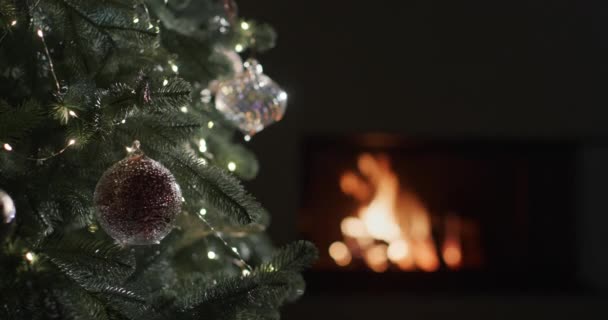 Einem Dunklen Raum Brennt Einem Kamin Ein Feuer Verschwommene Christbaumbeleuchtung — Stockvideo