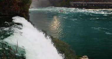 Niagara Şelalesi 'nin suları, turistlerle dolu tekneye doğru akıyor. Gün batımından önce akşam.