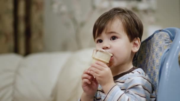 2歳のアジアの赤ちゃんはアイスクリームを食べます 給餌のためのチャイルドシートに座っています — ストック動画