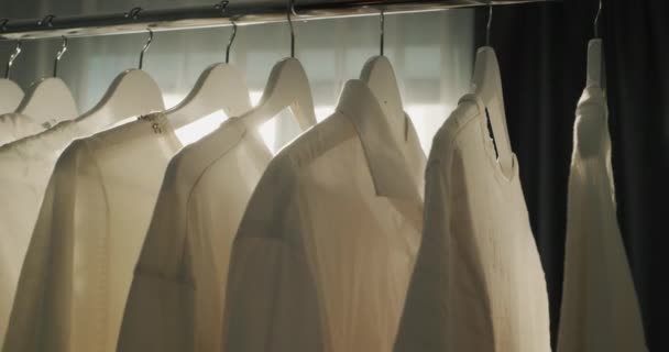 Rack Met Witte Shirts Hangers Zon Verlicht Kleren Prachtig — Stockvideo