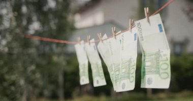 Euro banknotes hanging in the wind on a clothesline. Money laundering concept.