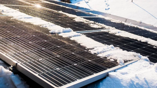 Snow melts on solar panels with the arrival of spring.