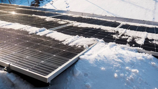 Snow melts on solar panels with the arrival of spring.