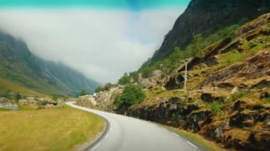 Norveç 'in dağları arasındaki manzaralı yoldan git. Birinci şahıs görünümü.