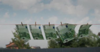 Euro banknotes hanging in the wind on a clothesline. Money laundering concept.