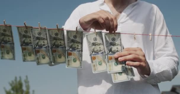 男人把钞票从晾衣绳上取下来 洗钱概念 — 图库视频影像