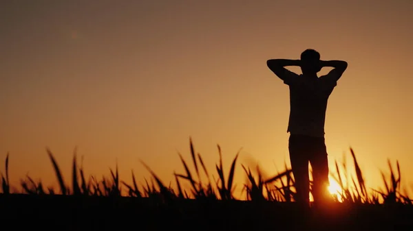 Silueta Mladý Muž Těší Čerstvý Vzduch Obdivuje Západ Slunce Drží — Stock fotografie