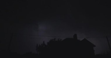 Flashes of lightning over the night street illuminate the house. Strong storm with thunder. 4k timelapse