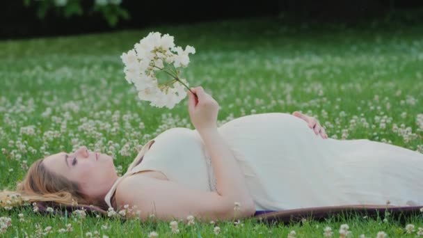 Cute Pregnant Woman Lies Lawn Holds Flower Her Hand Dreams — Vídeo de Stock