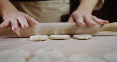 Becerikli bir aşçı hamur işi yapar. Hareketleri hızlı ve profesyonelce.