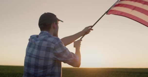 Silueta Joven Ondeando Bandera Americana Pie Campo Trigo Atardecer — Vídeos de Stock