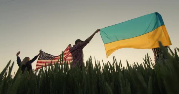 一群朋友把美国国旗和乌克兰国旗举过头顶 低角度射击 — 图库视频影像