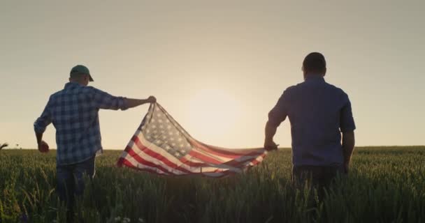 Dos Hombres Levantan Bandera Estados Unidos Contra Telón Fondo Campo — Vídeos de Stock