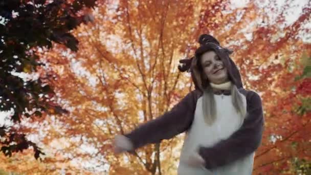 一个穿着鹿衣的孩子在一棵秋天的树上跳舞 — 图库视频影像