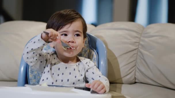 Cute Asian Baby Independently Eats Porridge His Plate Sits Chair — Stock Video