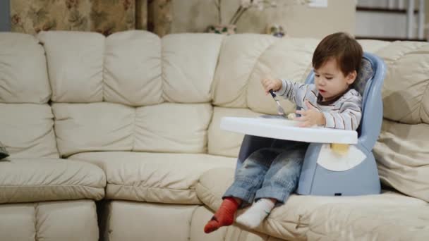 Cool Little Boy Eats Dumplings His Own Sits High Chair — Stock Video