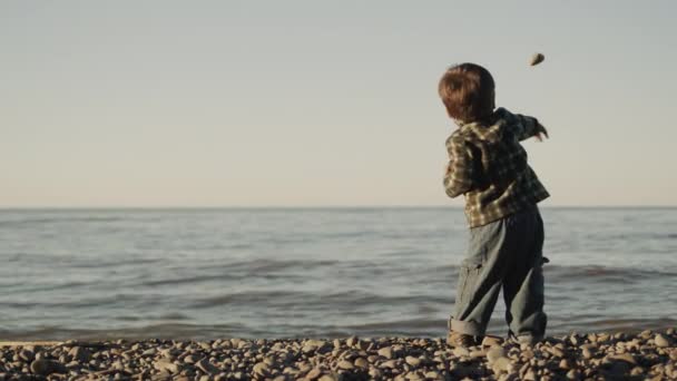 Ένα Επίμονο Αγόρι Δύο Ετών Πετάει Μια Πέτρα Στη Θάλασσα — Αρχείο Βίντεο