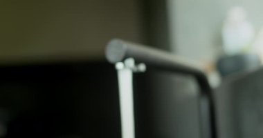 Modern bir mutfak musluğundan su akar. Kaydırıcı atışı.