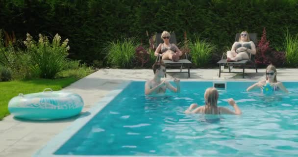一群朋友在游泳池里玩球 然后在游泳馆里放松一下 在房子的后院里玩吧 — 图库视频影像