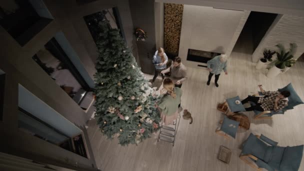 多代同堂的家庭在客厅里用壁炉装饰一棵大圣诞树 — 图库视频影像