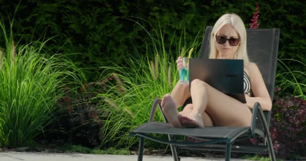 Mulher Atraente Está Relaxando Uma Espreguiçadeira Usando Laptop Beber Coquetel — Vídeo de Stock